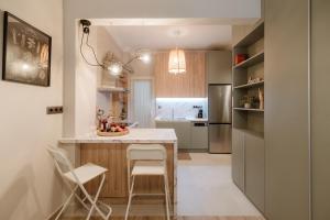 塞萨洛尼基Urban Jasmine的厨房配有桌椅和冰箱。