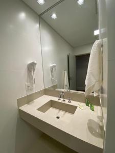 陶巴特KEEP SUÍTES HOTEL的一间带水槽和大镜子的浴室