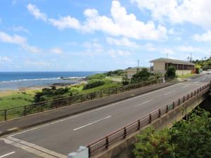 德之岛Yugaku Resort Kimukura - Vacation STAY 89356v的一条空的路,在后面是大海