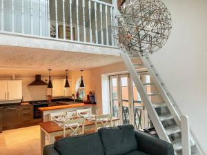 新港Riverside loft apartment的一间带楼梯的客厅和一间厨房
