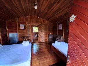 El AchioteCabañas Los Laguitos Rio Celeste的一间卧室配有两张床,卧室内配有沙发