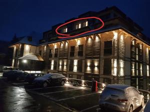 科帕奥尼克Family apartmans Hari - Apart Hotel & spa Zoned, Kopaonik - Children up to 13 years free!的建筑的侧面有 ⁇ 虹灯标志