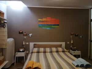 古斯皮尼B&B Annalu'的卧室配有一张床,墙上挂有绘画作品