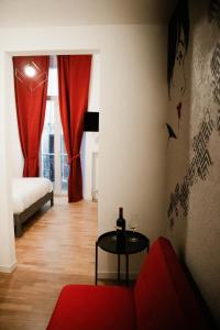 阿斯科利皮切诺BED and BREAKFAST il Duomo的客厅配有红色的沙发和桌子