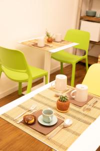 阿斯科利皮切诺BED and BREAKFAST il Duomo的一张带绿椅的桌子和一张带咖啡杯的桌子