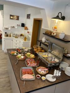 维林根Landhaus am Itterbach Willingen的厨房的柜台上放着许多盘子的食物