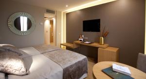 塞维利亚塞维利亚国会M.A.酒店的一间卧室配有一张床、一张桌子和一面镜子