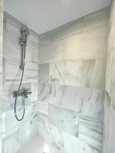 马德里BNBHolder PALACIO DE CRISTAL es MIA的一间设有白色大理石墙壁和淋浴的浴室