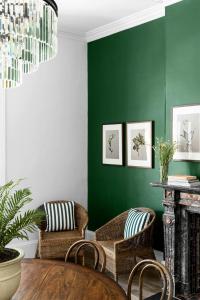 悉尼Hotel Challis Potts Point的客厅设有绿色的墙壁和藤椅