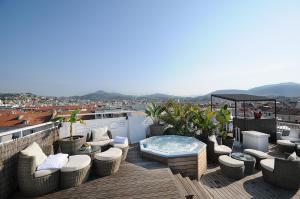 尼斯尼斯灿烂酒店的一个带椅子的庭院和一个屋顶热水浴池