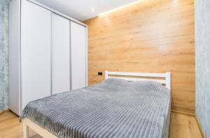 基辅Квартира в Мега Сити的一间卧室设有一张床和木墙