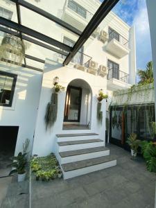雅加达Loewys Home Tanjung Duren Jakarta Barat的前面有楼梯的白色房子