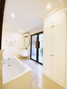 雅加达Loewys Home Tanjung Duren Jakarta Barat的白色的浴室设有浴缸和水槽。