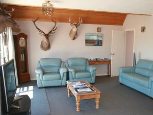 特卡波湖鱼篓屋住宿加早餐旅馆的客厅配有2把蓝色椅子和桌子