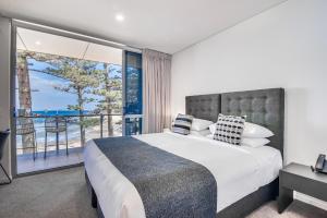 奥斯汀莫奥斯汀海滩海角酒店的一间带大床的卧室和一个阳台