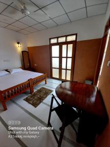 希克杜沃La-Vira Beach Villa的一间卧室配有一张床、一张书桌和一个窗户。