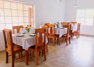 尼格瑞尔Sommerville Resorts的用餐室配有白色的桌子和木椅