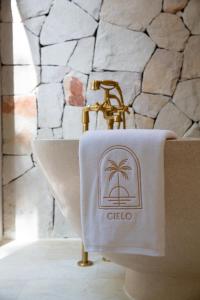 波普托Cielo Boutique Hotel & Spa Samui的浴室水槽上方的毛巾