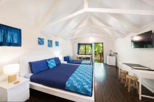 埃尔利海滩Airlie Beach Magnums - Adults Only的白色卧室配有蓝色的床和书桌