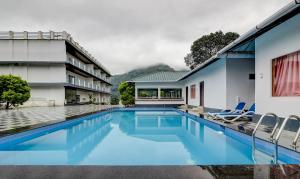 蒙纳Treebo Trend Misty Garden Resorts With Mountain View的一座房子后院的游泳池