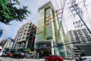 宿务Goldberry Suites and Hotel Cebu的城市街道上一座高大的建筑,设有玻璃窗