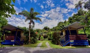 苦难角丹特里桑顿海滩度假屋的一排带蓝色门和棕榈树的小屋