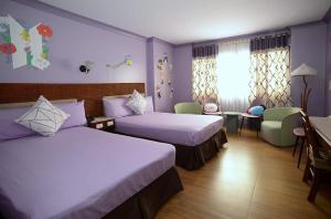 碧瑶金松酒店的酒店客房设有两张床和一张桌子。
