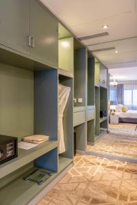 马累Manhattan Business Hotel, Male的一间设有绿色橱柜的房间和一间客厅