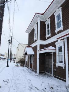 函馆元町の宿　雪月花的一间棕色的房子,旁边是雪