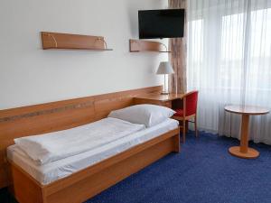 布拉格ILF酒店的一张位于带书桌和电视的客房的床铺