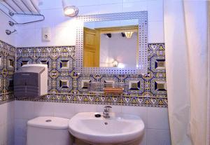 塞维利亚里斯旅馆的一间带水槽、卫生间和镜子的浴室