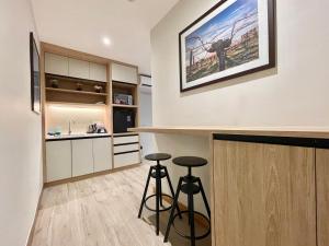 瓜埠LV Modern Suite Langkawi by Zervin的厨房配有2张吧台凳和1个柜台。