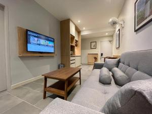 瓜埠LV Modern Suite Langkawi by Zervin的客厅配有沙发和墙上的电视