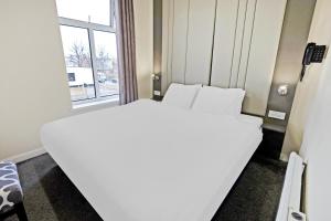 米德尔斯伯勒OYO The Baltimore Hotel的窗户客房内的一张白色床