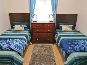 MaclearFairbairn Guest Farm的一间卧室设有两张床、一个梳妆台和窗户。