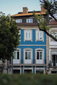 布拉加Lux Housing Século XXI的蓝色的建筑,在街上有白色的窗户