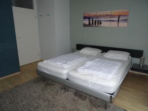 布雷斯肯斯Kustverhuur, Appartement aan Zee, Prachtig appartement op de begane grond PS 13-001的卧室里一张带白色床单的床