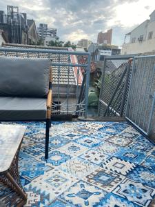 台南FunNan Guesthouse的阳台配有椅子和地毯,位于地板上