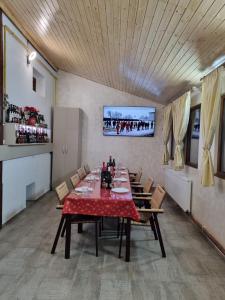 TălpăşeştiPensiunea Rares的一间用餐室,配有红色的桌子和椅子