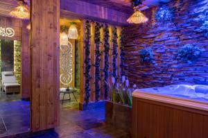 扎科帕内Hotel Zakopane Wellness & SPA ex Korona Tatr的一间带石墙和浴缸的浴室