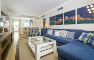 EsteponaHB Comfortable Beachfront Holiday Apartment的客厅配有蓝色的沙发和桌子