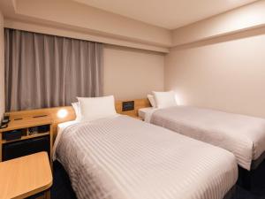 Sotetsu Fresa Inn Nagoya-Shinkansenguchi客房内的一张或多张床位