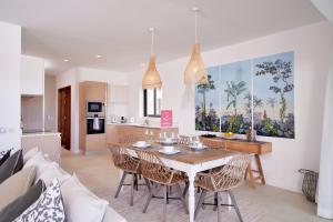 康隆尼角Nautilya Apartment by LOV的厨房以及带桌椅的用餐室。