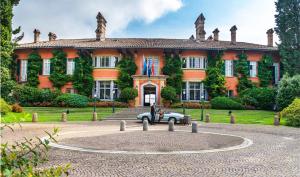 卢加诺Villa Principe Leopoldo - Ticino Hotels Group的前面有一辆汽车,有一个大型的橙色房子