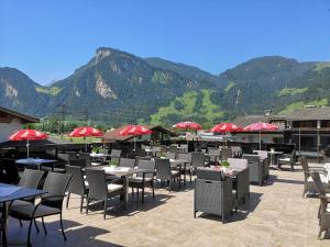 奇勒谷地拉姆绍特蕾西亚酒店的餐厅配有桌椅,位于山脉的背景中