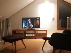 洛索内LA TICINELLA的客厅配有一张桌子,电视