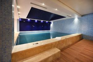 拉巴特Flower Town Hotel & Spa的浴室内设有一个带浴缸的浴室的游泳池