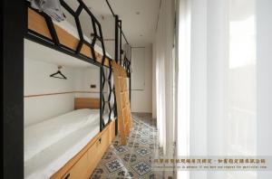 台南掘旅青年旅舍的一间带两张双层床的卧室,铺有瓷砖地板。