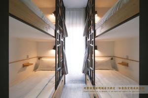 台南掘旅青年旅舍的带窗户的客房内的两张双层床