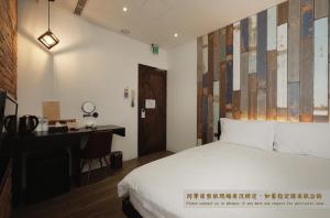 台南掘旅青年旅舍的酒店客房配有一张床、一张书桌和一张书桌。